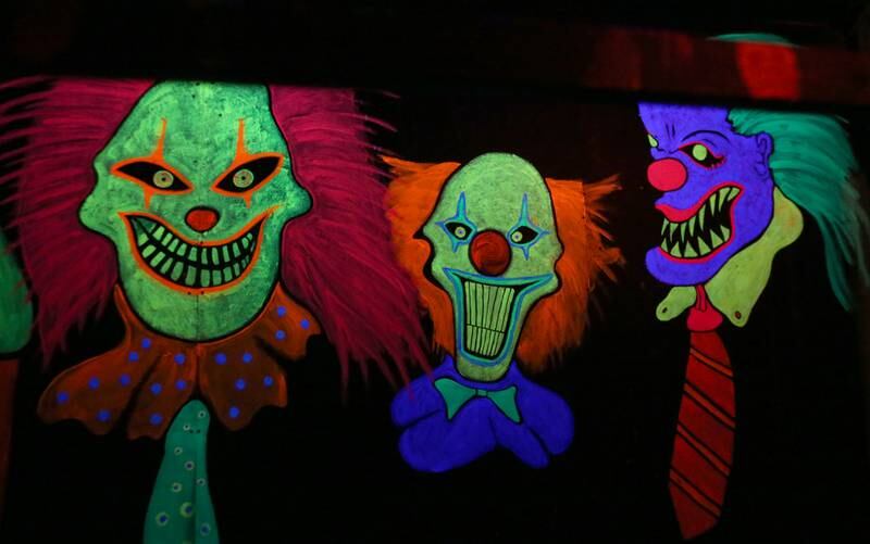 Clowns illuminate under a blacklight during the Nightmare Haunted Attraction on Saturday, Oct. 14, 2023 at the Bureau County Fairgrounds in Princeton.