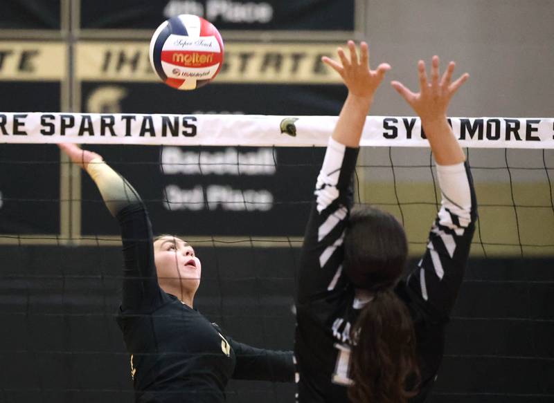 Sycamore's Kylie Walsh tries to spike the ball by Kaneland's Olivia d’Escoto during their match Tuesday, Oct. 1, 2024, at Sycamore High School.