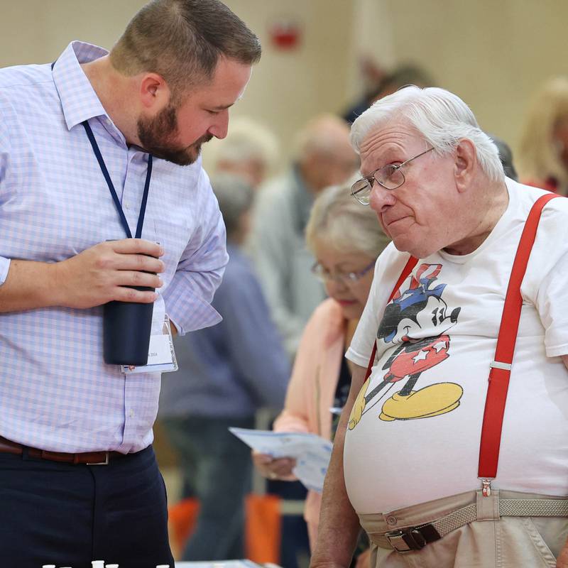 William Stewart, (right) from Sandwich, listens as Sam Olson, from Walgreens, answers a question during a senior health fair Wednesday, July 12, 2023, at DeKalb High School.