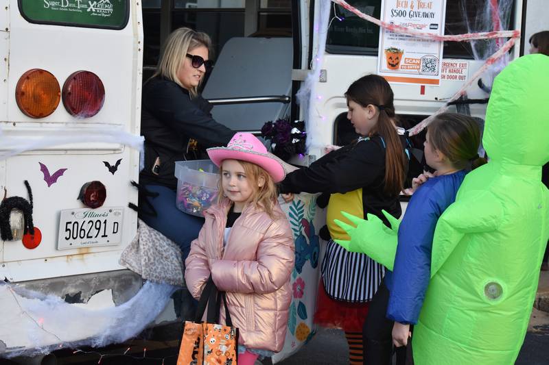 The Rock Falls Chamber of Commerce passes out candy to trick-or-treaters, Friday, Oct. 24, 2025.