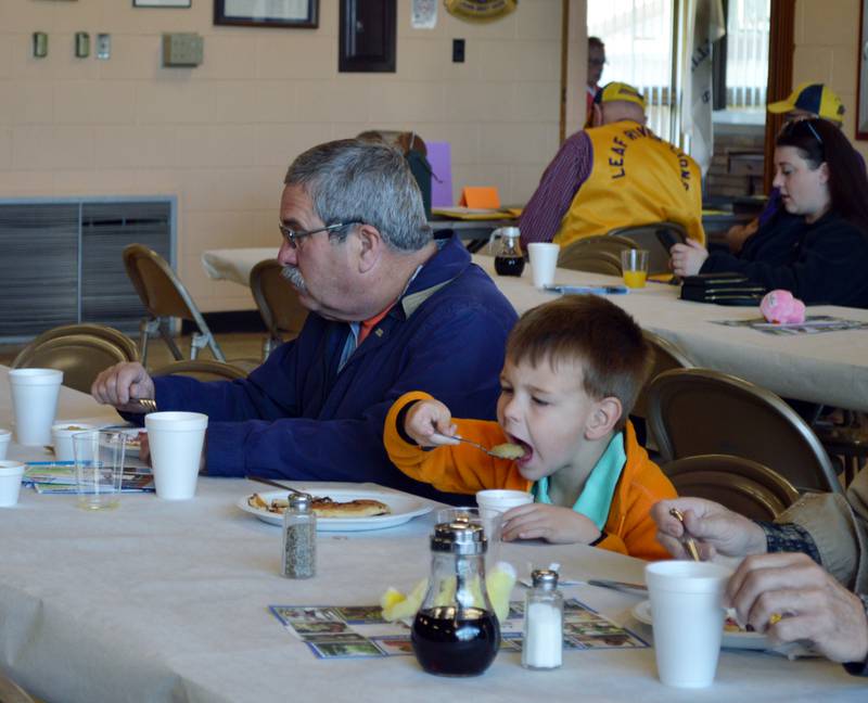 Jagger Howald, 4, of Winnebago, right, takes a bite of applesauce as he sits next to grandfather Mike Howald, of Forreston during the Leaf River Lion's annual Breakfast with Bunny in the Bertolet Memorial Building on April 16.