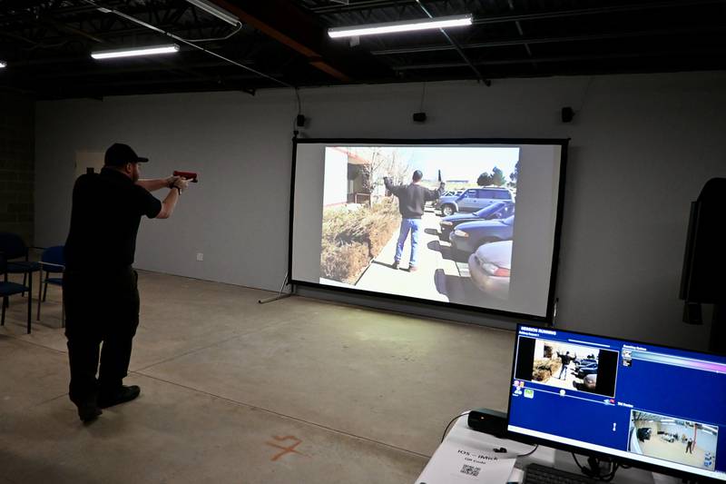 Field Training Officer for the Ottawa Police Department Joel Smith reacts to a bank robbery scenario using the Driving Simulator/Milo Range Pro 4 K Training Simulator.