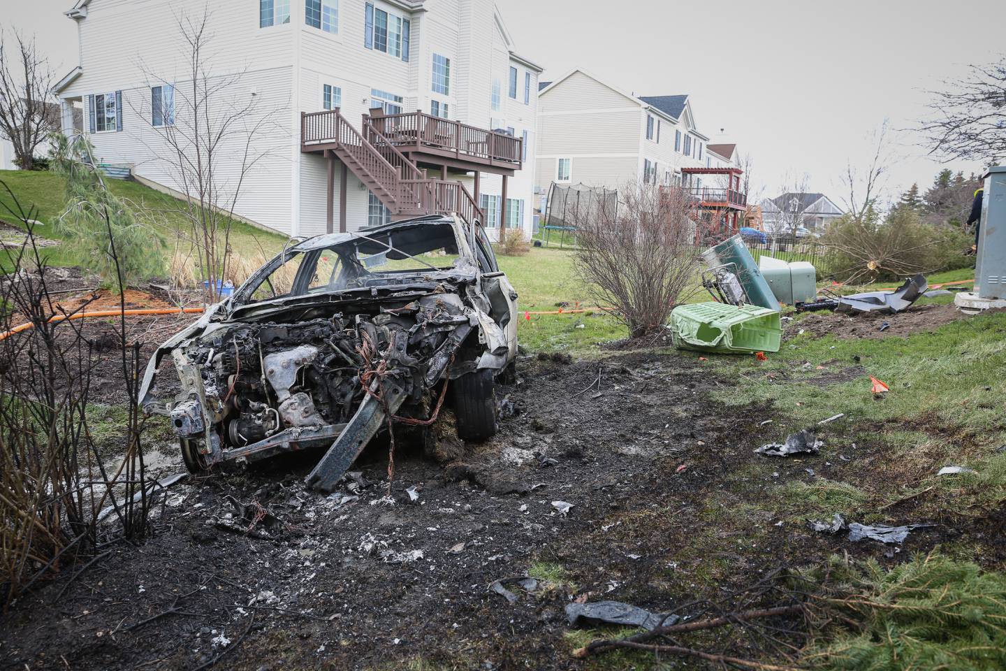 The remains of a vehicle that crashed into a neighborhood backyard near Huntley on Thursday afternoon, April 14, 2022. The vehicle had crashed into a pole, flipped over and ended in the yard before catching fire, police officials said.