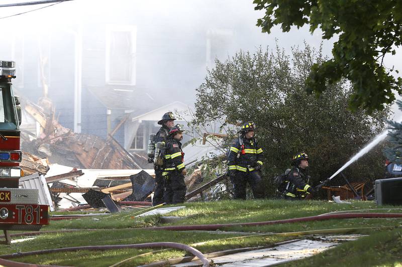 Firefighters battle a house fire in the 300 block of Lincoln Avenue in Woodstock Monday, Oct. 9, 2023, after an explosion following suspected gas leak in the area.