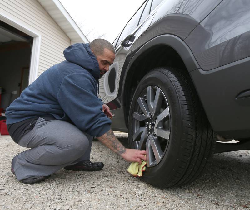 Jose Pabon wipes down his wheels of his car with a vinegar and hydrogen peroxide solution at his home near Zinc and Oconor Avenue on Thursday, Jan. 12, 2023.