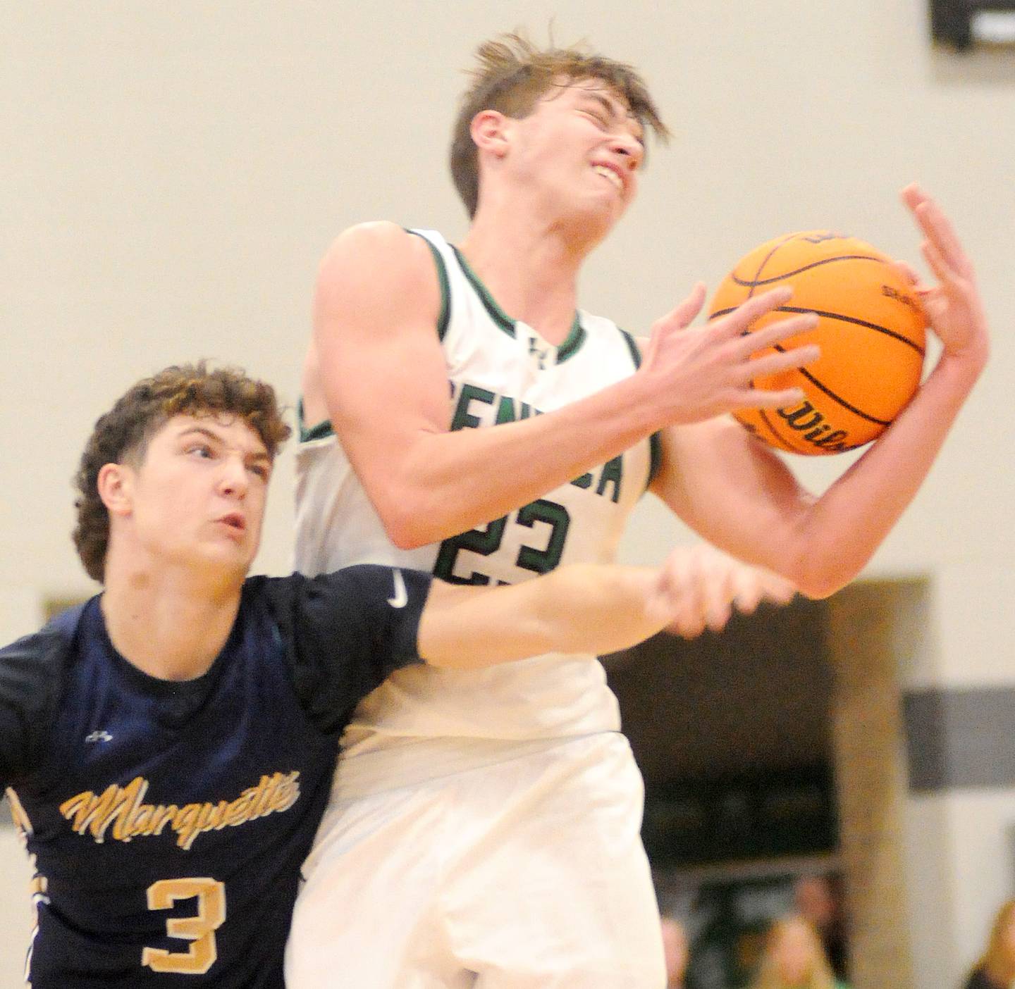 Seneca senior forward Brady Sheedy (23) grabs a loose ball as Marquette junior guard Easton DeBernardi reaches for it on Friday, Dec. 5, 2025 at Seneca High School.