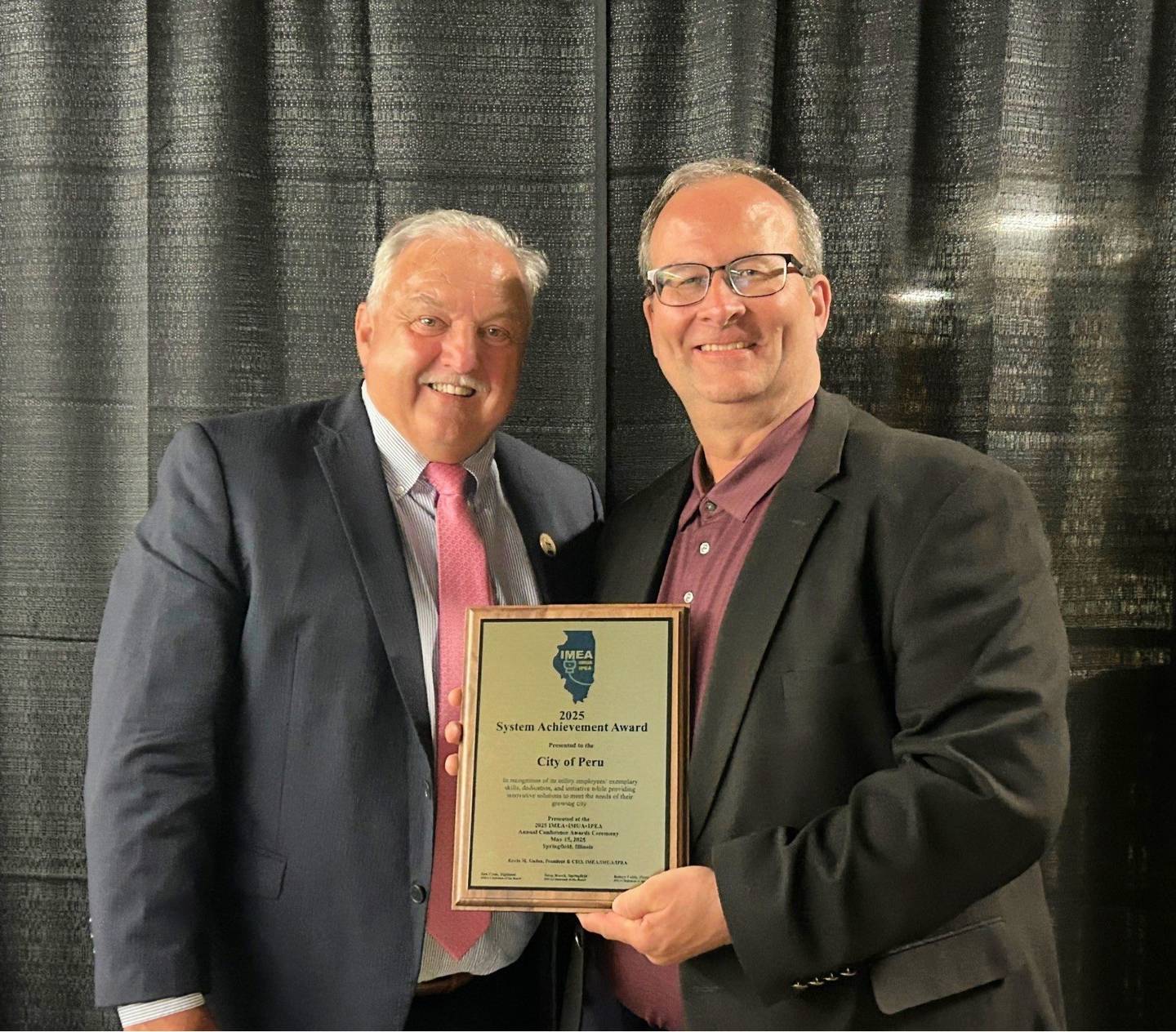 Accepting the 2025 IMUA System Achievement Award from IMEA/IMUA/IPEA President & CEO Kevin Gaden is City of Peru Mayor Ken Kolowski.