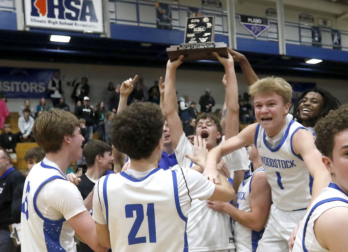 Woodstock's Max Beard raises the trophy  with his teammates after Woodstock defeated Woodstock North to win the Kishwaukee River Conference boys basketball championship on Wednesday, February. 18, 2026, at Woodstock High School.