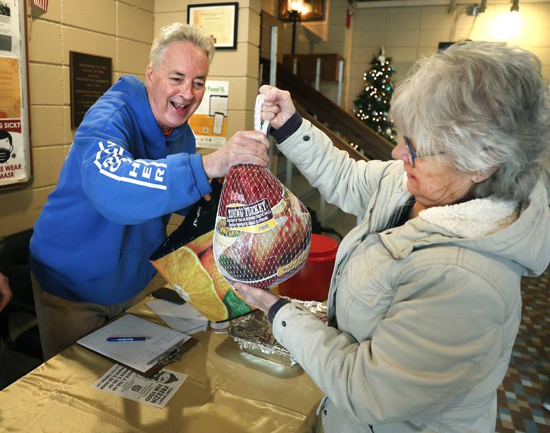 Cheryl Johnson, from Cortland, hands her turkey donation to TD Ryan, host of the TD Ryan Unleashed podcast, during Ryan’s Let’s Talk Turkey Thanksgiving food drive Friday, Nov. 21, 2025, at the Salvation Army food pantry in DeKalb.