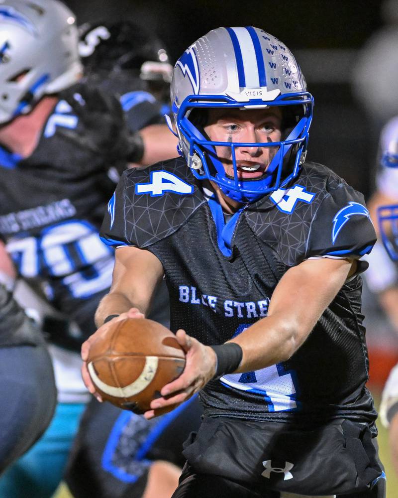 Woodstock's Caden Thompson hnads the ball off during their game against Kishwaukee River Conference and crosstown rival Woodstock North on Friday, Oct. 25, 2024 at Woodstock H.S.