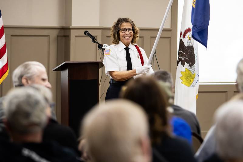 Veronica Konow presents flags representing branches of armed services during a Veterans Day ceremony at American Legion Post 1080 in Joliet on Nov. 11, 2025.