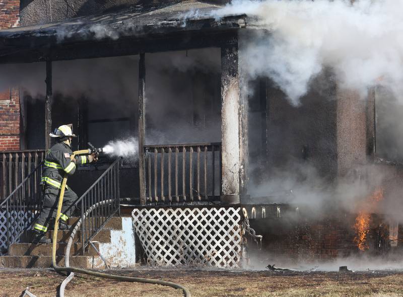 Utica Fire Chief Ben Brown, sprays water on the front porch of house fire in the 800 block of Bucklin Street on Friday, Jan. 23, 2026 in La Salle.