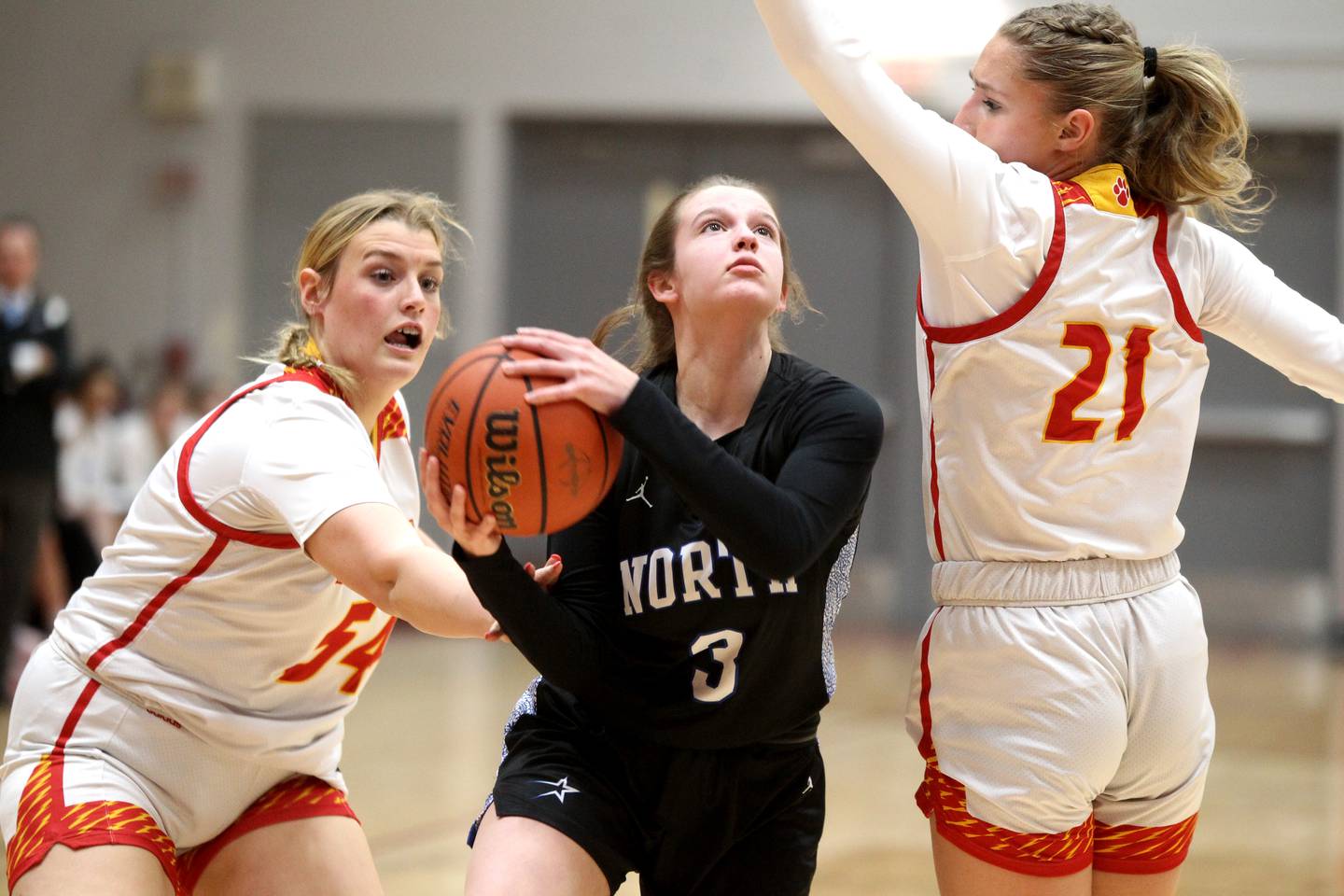 St. Charles North’s Alyssa Hughes (center) puts up a shot between Batavia defenders Sarah Hecht (left) and Kylee Gehrt (right) during a game at Batavia on Thursday, Jan. 12, 2023.