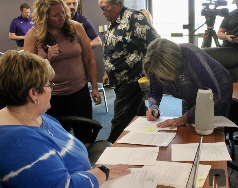 From left, Dixon Public Schools Superintendent Margo Empen, Maranda Dallas of the Dixon Education Association and Linda Wegner, board president, during document signings pertaining to two actions on Monday, May 22, 2023, at the special meeting of the board of education.