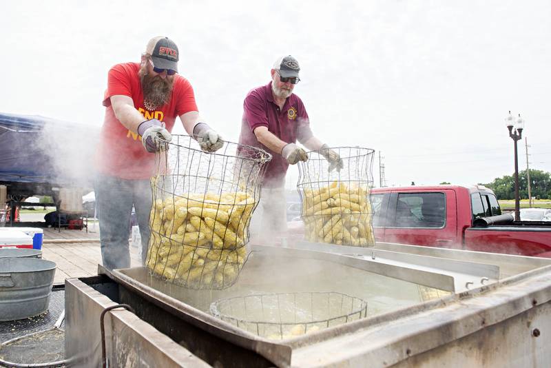 Mike Albert (left) and Eric Epps pull out some hot and tasty sweet corn Monday during the Sterling Noon Rotary and Rock Falls Rotary Club’s annual Broil and Boil. Customers received a barbecue pork chop sandwich and a couple ears of corn. The money goes to help the clubs’ many programs.