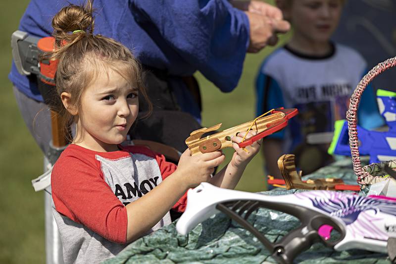 Zoey Albee, 5, of Sterling reacts to firing off a play crossbow Saturday, Sept. 23, 2023 at Lowell Park. Members of the CER LARP (Live Action Role Players) group had on display a variety of gear that visitors could test as they slay that dragon.