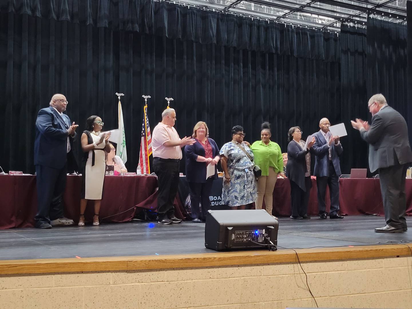 Members of the Kankakee School Board and their families stand on stage as five members take oaths of office on May 12, 2025, at Kankakee High School.
