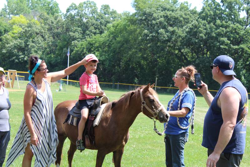 Glory Bound Rescue Ranch founder Jennifer Finkelman, right, helps a kid ride Fancy the horse at the Island Lake July 4 picnic on July 4, 2023.
