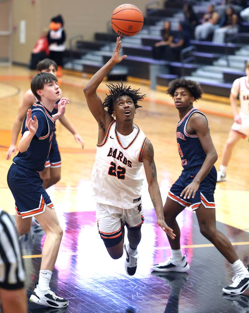 DeKalb's Darrell Island tries to get a shot up as he stumbles between two Naperville North defenders during their game Monday, Jan. 30, 2023, at DeKalb High School.