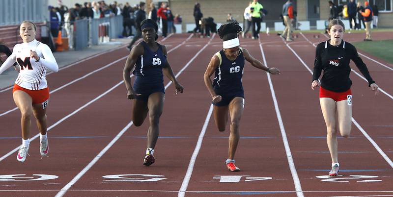 McHenry’s Addison Hoffmann (from left to right), Cary-Grove’s Fiyinfunoluwa Onafeko, Cary-Grove’s Olivia Parker and Huntley’s Rachel Hogan  race to the finish line in the 100 meter dash on Thursday, May 7, 2026, during the Fox Valley Conference Girls Track and Field Meet at Huntley High School.