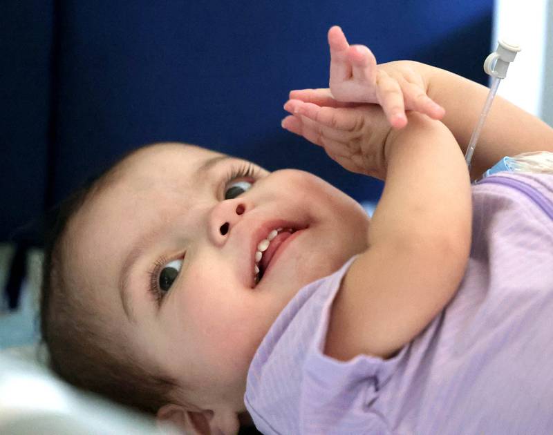 Marely Chavarria Santos, 1, claps in her crib Monday, June 30, 2025, at her home in DeKalb. Marely was born with a myriad of health issues that require around-the-clock care and recently received a heart transplant.