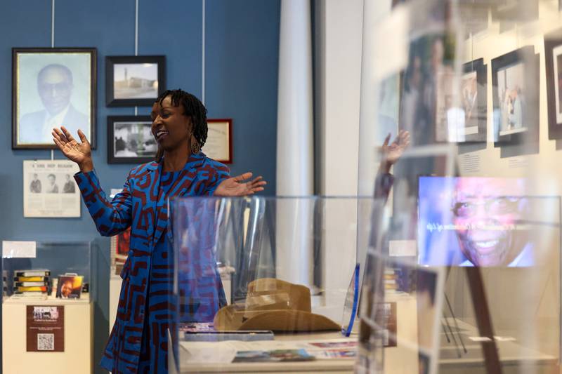 Surrounded by items from her father's life and a reflection of a memorial video, Monica Fountain, daughter of the late Kankakee civil rights leader Rev. William Copeland, joins in singing with the crowd during the opening of the exhibit 'Called to Kankakee: The Life and Legacy of the Rev. William H. Copeland Jr.' at the Kankakee County Museum on Saturday, Feb. 7, 2026.
