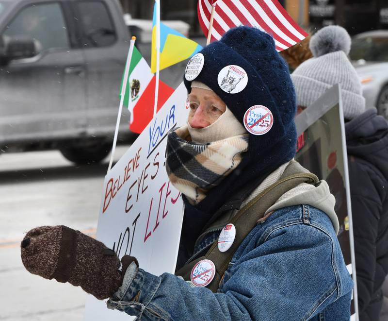 A woman carries a sign that reads "Believe Your Eyes, Not Their Lies" at the Indivisible of Ogle County's protest held in downtown Oregon on Sunday, Jan. 25, 2026. Around 120 people attended the event carrying signs criticizing the Trump administration's deployment of ICE officers and the shooting death of Alex Pretti by ICE agents on Saturday in Minneapolis.
