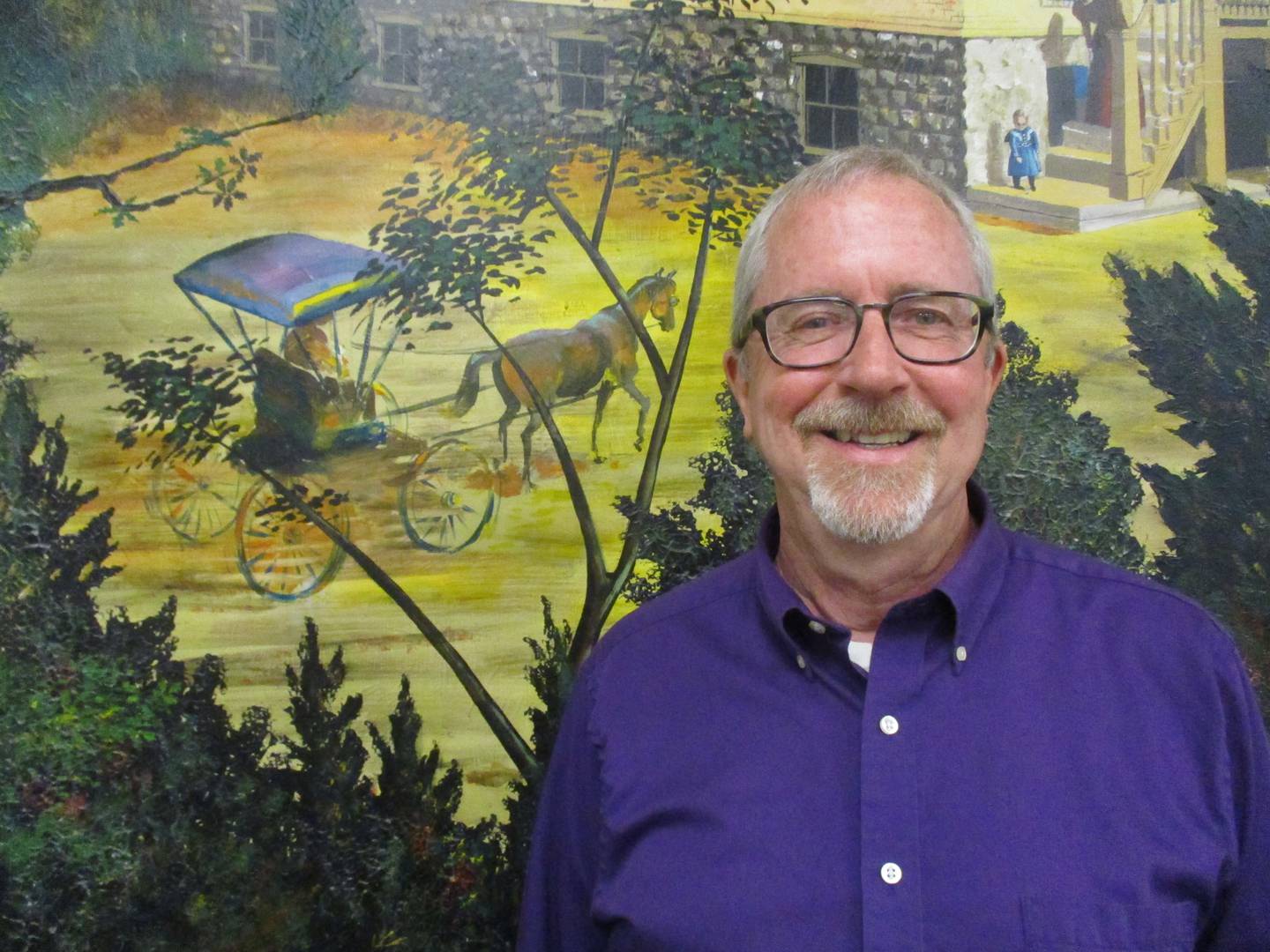 Plano Mayor Mike Rennels stands before a mural in the Plano City Council chambers.