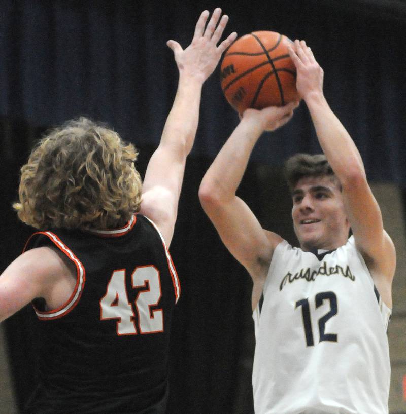 Marquette's Denver Trainor shoots past the defense of Roanoke-Benson's Zeke Kearfott at Bader Gymnasium on Friday, Dec. 15, 2023.