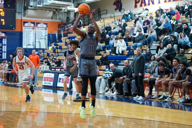 Oswego East's Reginald McWaine (11) shoots the ball during a basketball game against Oswego at Oswego High School on Tuesday, February 18, 2025.
