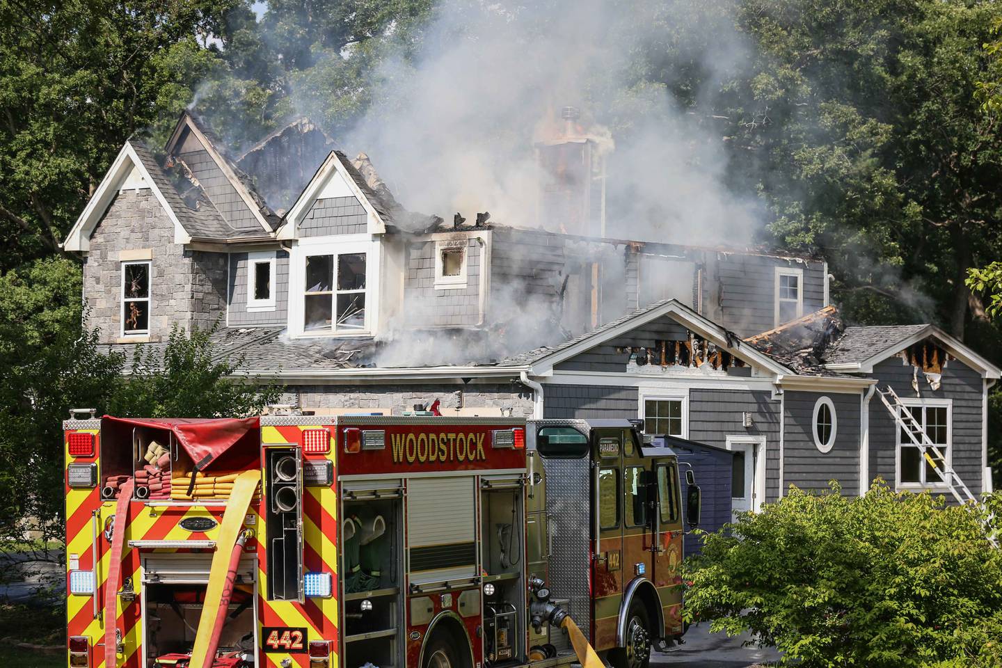 Woodstock Fire/Rescue District personnel work to put out a house fire on Friday, July 21, 2023.