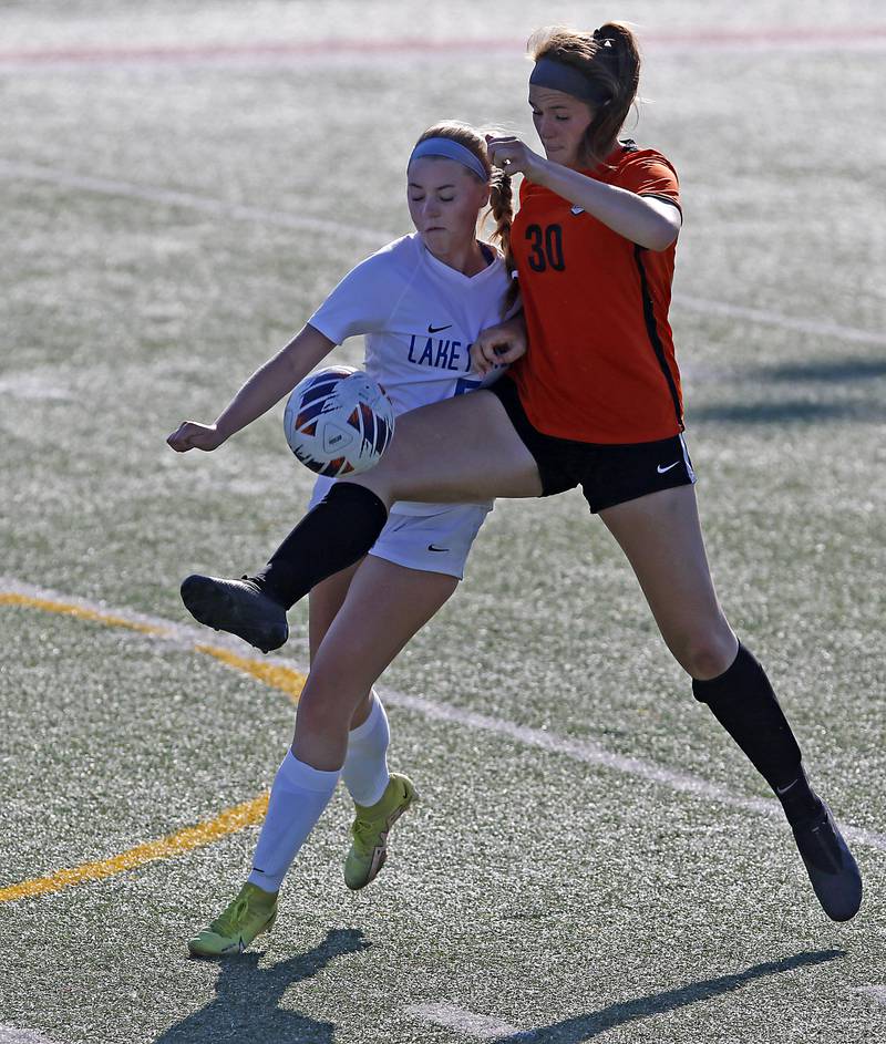 Crystal Lake Central's Shaylee Gough kicks the ball away from Lake Forest's Elizabeth Flynn during a Class 2A Deerfield Sectional semi-final match on Tuesday, May 21, 2024, at Deerfield High School.