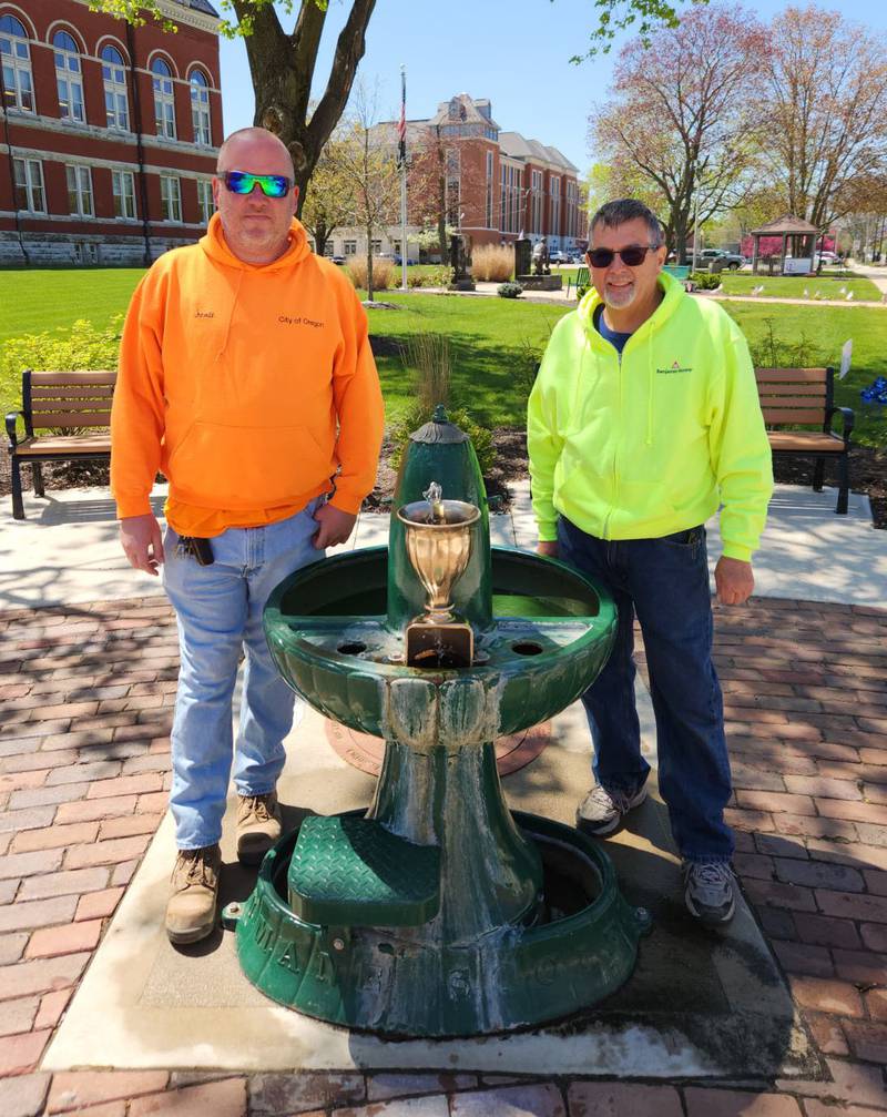 Oregon's iconic water fountain is up and running for the 2024 season. Former city worker Mike Bowers (right) along with Scott Wallace of the city's water department (left) and Jeff Pennington, also of the ater department (not pictured) got the historic fountain ready last week. The free flowiing fountain is located on the corner of Fourth and Washington Streets in downtown Oregon. It was installed in the early 1900s by the Illinois Humane Society and provides three drinking levels – one for humans, one for dogs, and one for horses.