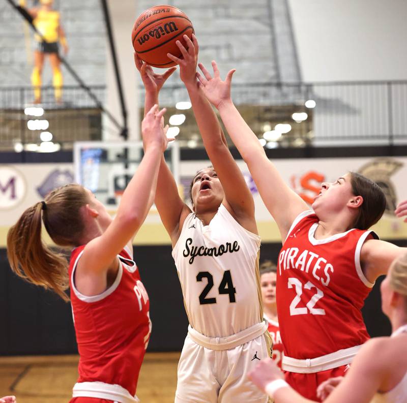 Sycamore's Monroe McGhee goes after a rebound between Ottawa's Hailey Larsen (left) and Marlie Orlandi Wednesday, Jan. 4, 2023, during their game at Sycamore High School.