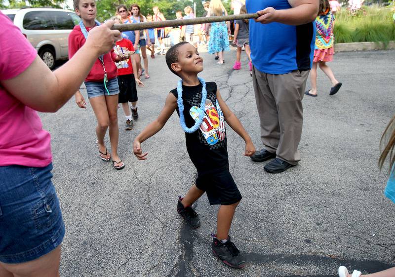 Zion Watts, 5, passes under a limbo stick with ease at Sycamore Library's first beach party on Friday, August 1, 2014.