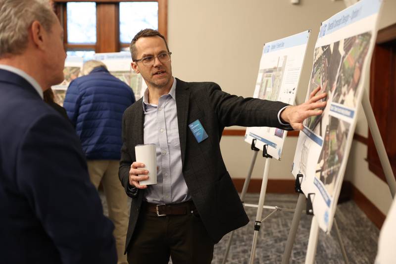 Phil Hutchinson, of Civiltech Engineering Inc, goes over designs for the proposed plaza with several guest during the City of Joliet downtown plaza open house at the Joliet Public Library on Thursday, February 23rd, 2023.