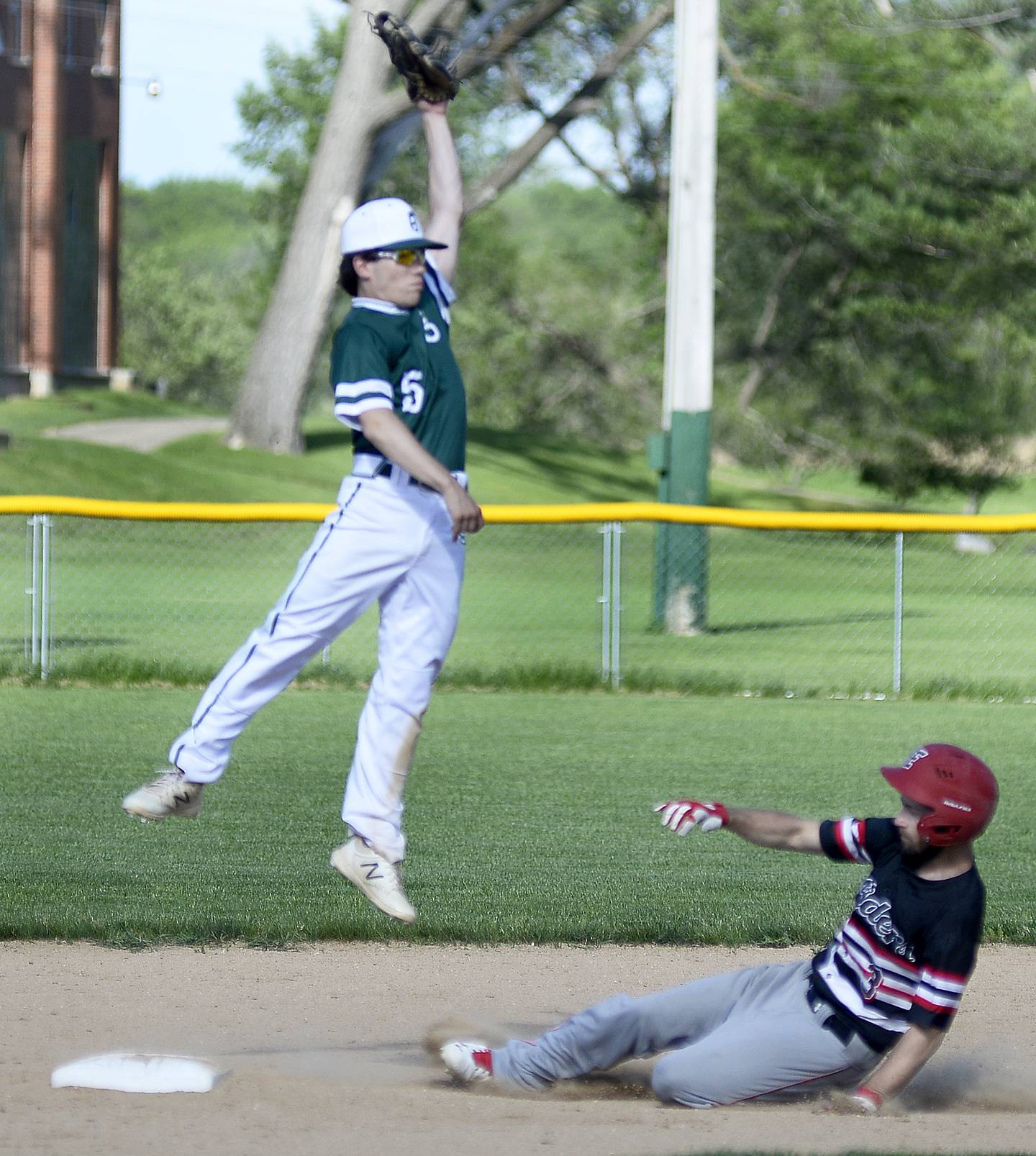 St. Bede second baseman Colin Nave (5) skies for the throw from home while Earlville baserunner slides into second safely Monday, May 16, 2022.