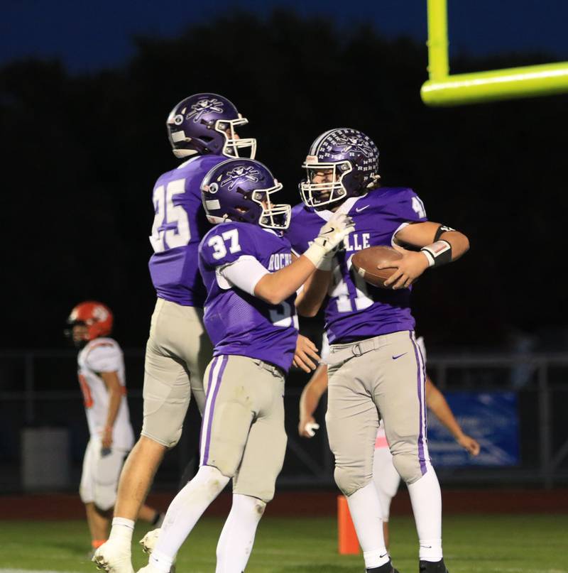 Rochelle's Tyler Gensler (41) celebrates his touchdown with teammates Jonathan Andrist (37) and Brode Metzger (25) during Friday's game with Waterloo.