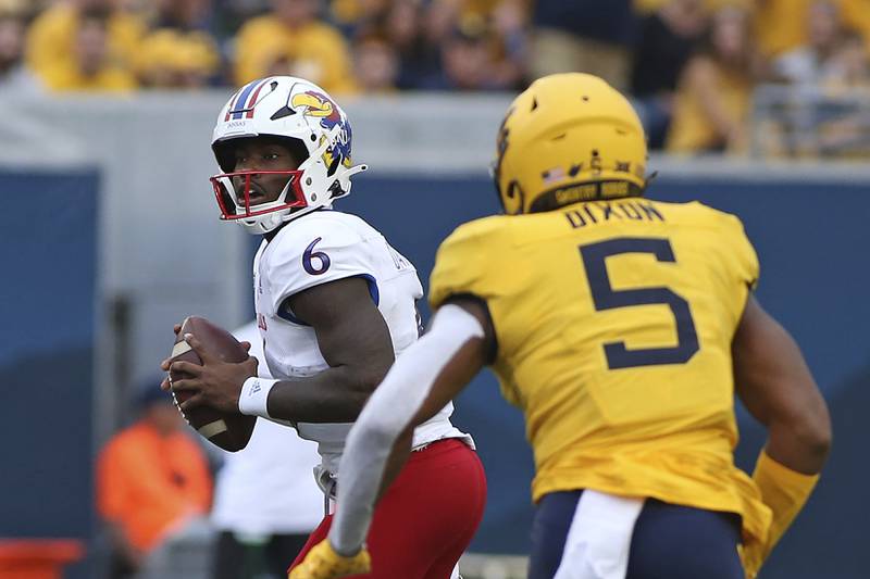 Kansas quarterback Jalon Daniels (6) is defended by West Virginia linebacker Lance Dixon (5) during the first half of an NCAA college football game in Morgantown, W.Va., Saturday, Sept. 10, 2022. (AP Photo/Kathleen Batten)