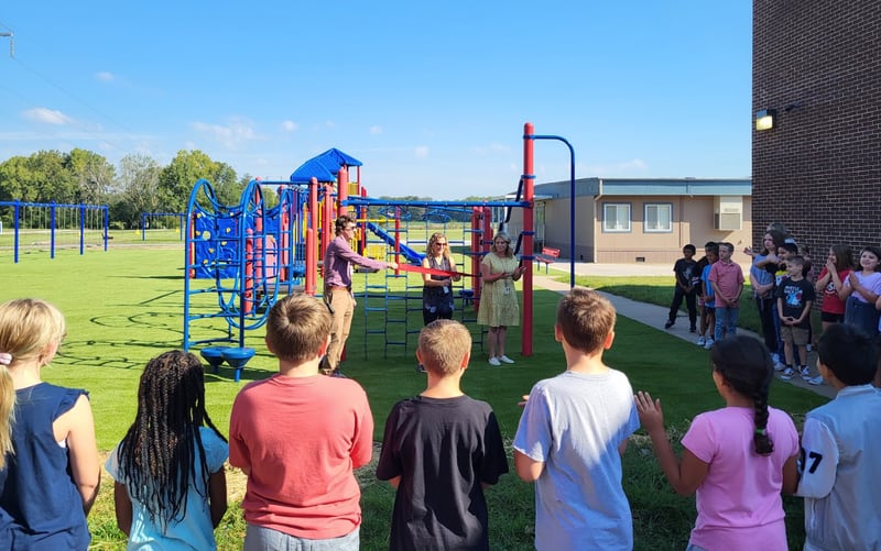 Centennial School Principal Steve Bruck, former principal and project initiator Susan Thrush and Assistant Principal Kammiroen Reilly hold the ribbon cutting ceremony for the new playground at Centennial with fourth graders looking on and cheering.