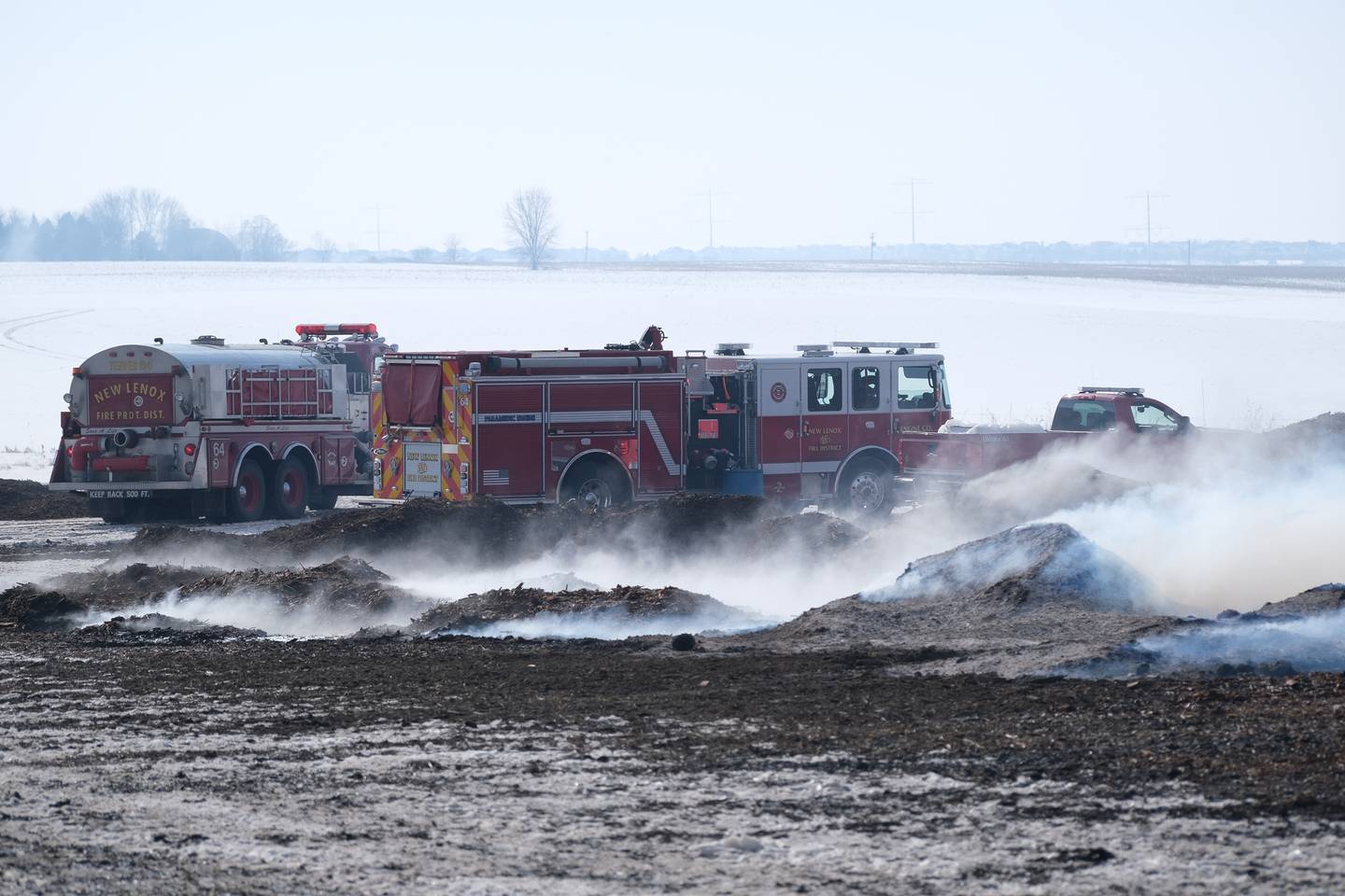 New Lenox fire trucks park near piles of smoldering mulch at 815 Mulch It in New Lenox. Monday, Jan. 31, 2022 in New Lenox.