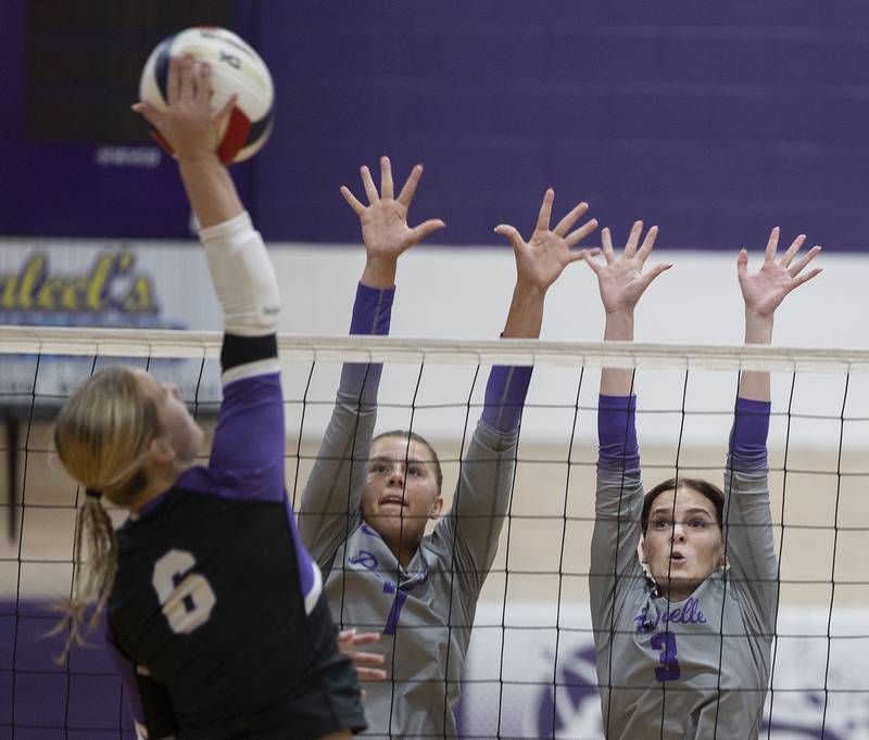 Rochelle’s Meredith Bruns (left) and Kyrie Cragin go up to makes a block against Dixon’s Rayven Mowery Thursday, August 28, 2025.
