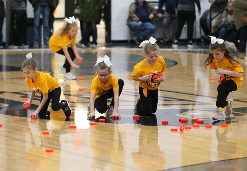 Putnam County youth cheerleaders pick up pucks after the "chuck a puck" toss during the halftime entertainment on Friday, Dec. 16, 2022 at Putnam County High School.