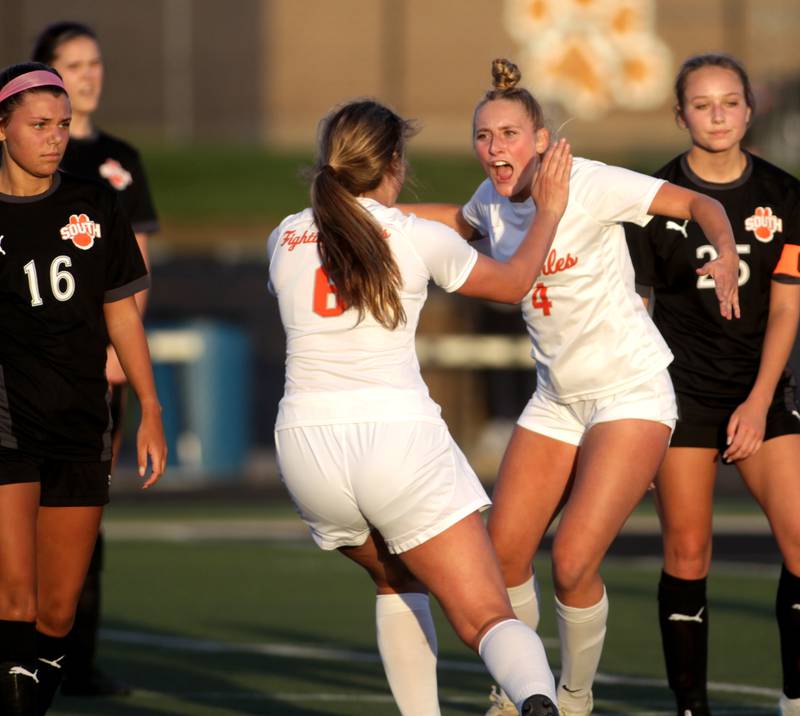 St. Charles East’s Grace Williams (center, right) and Mackenzie Loomis celebrate Williams’ goal during a game at Wheaton Warrenville South on Tuesday, April 18, 2023.