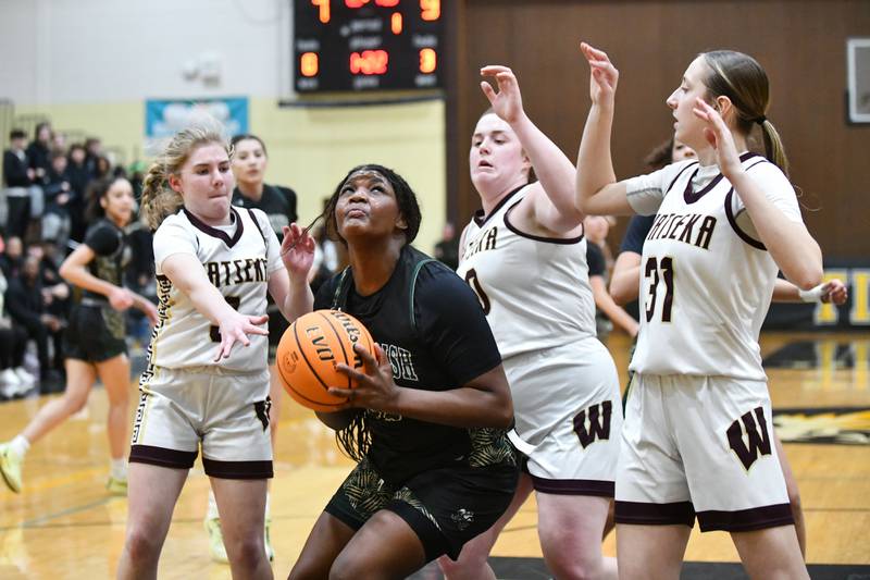 Bishop McNamara's Leigha Brown looks to shoot under pressure from Watseka-Milford's Rennah Barrett, left, Megan Martin, center, and Thayren Rigsby during the Fightin' Irish's 69-38 victory over Watseka-Milford in the IHSA Class 2A Herscher Sectional championship on Thursday, Feb. 27.