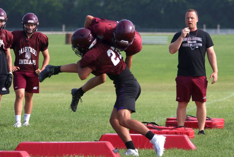 Assistant Coach Brad Wignes runs a drill during Marengo High School football practice Tuesday morning.
