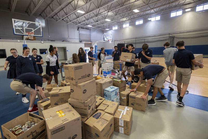 Newman High School students move food drive boxes to waiting buses Thursday, Oct. 3, 2024, at the high school. The food is destined for seven different local pantries.