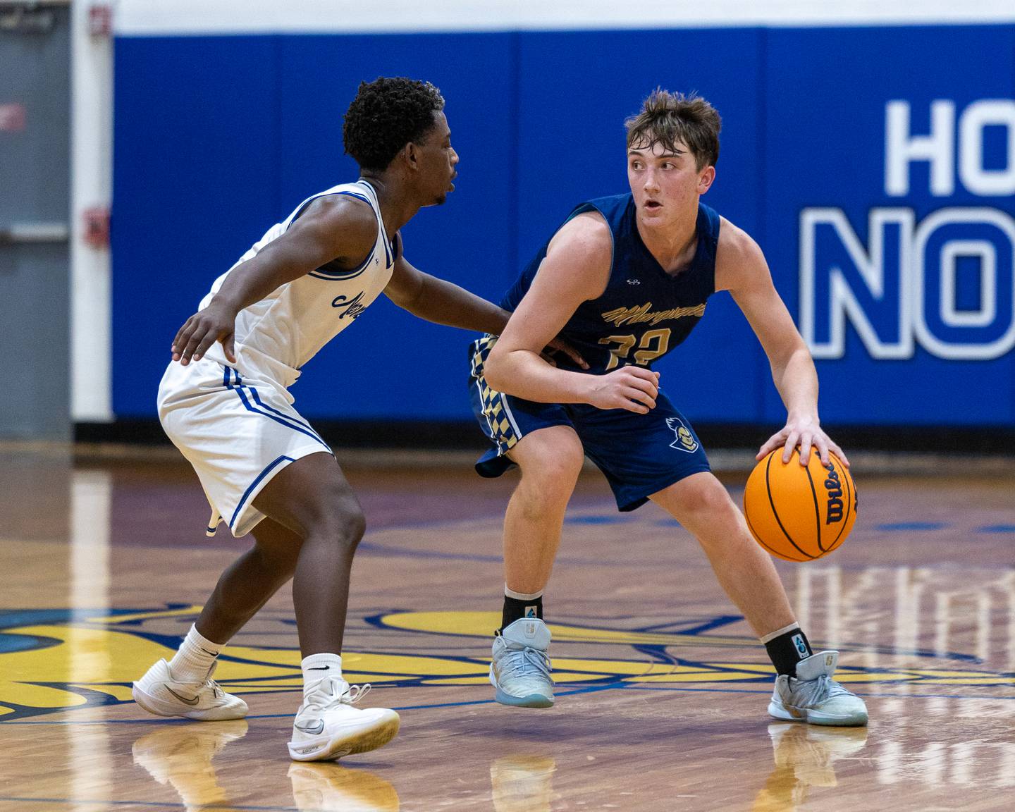 Marquette's Griffin Dobberstein (22) dribbles ball down lane as Nate Swenson (3) of Newark guards on Thursday, January 22, 2026 at Newark High School in Newark.