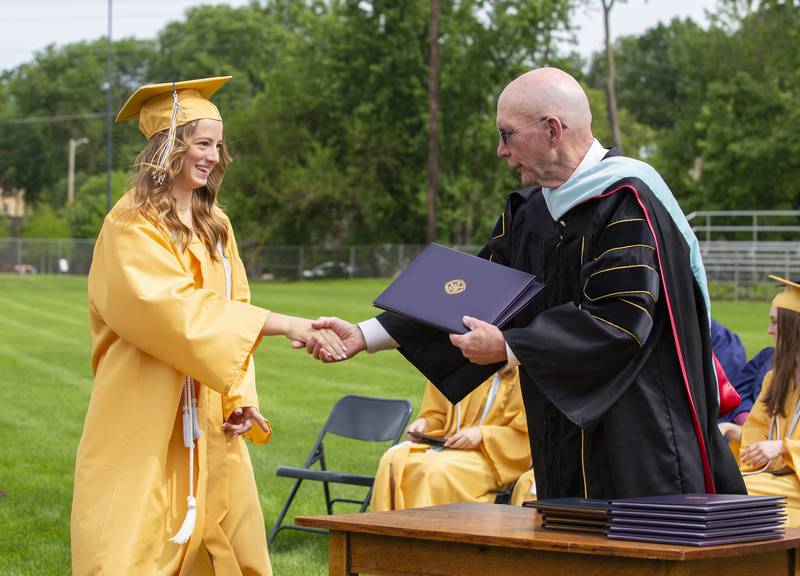 Marquette Academy Class of 2022 Valedictorian Isabel Garkey accepts both Associates of Arts and Associates of Science degrees from Illinois Valley Community College President Jerry Corcoran during the Sunday, May 29, 2022, commencement ceremony. She completed both degrees while in high school.
