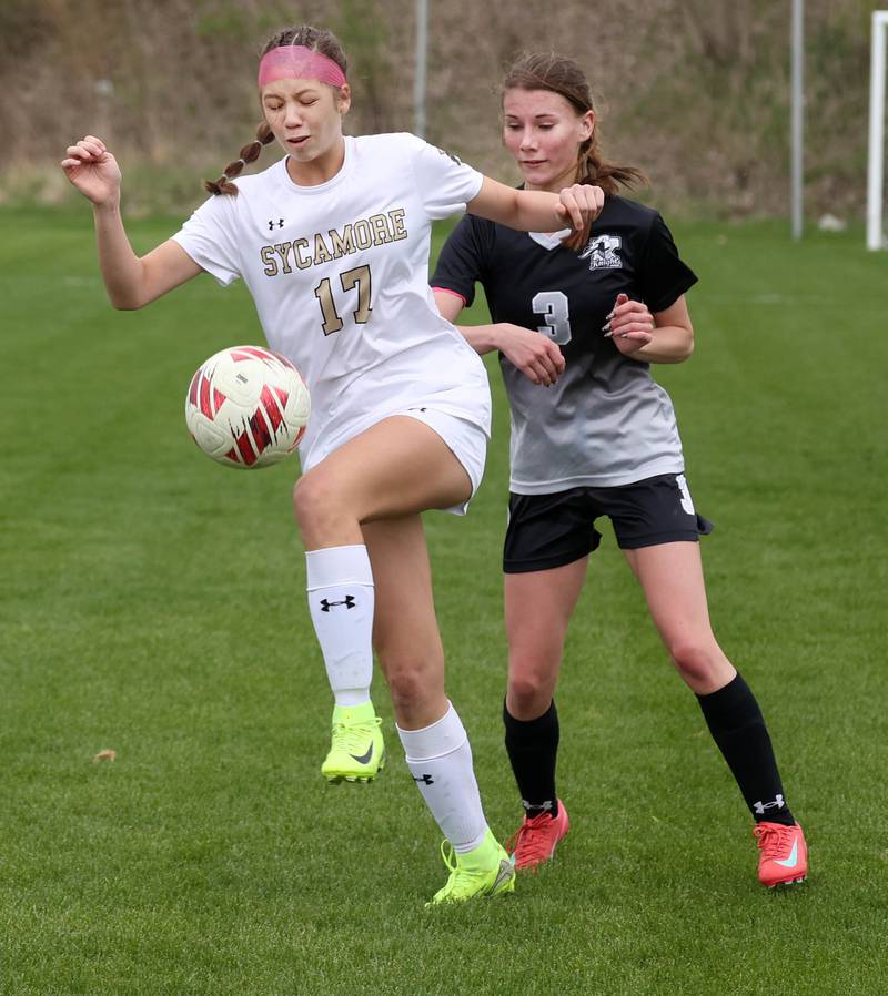 Sycamore's Addison Rodriguez (left) handles a throw in in front of Kaneland's Zoe Gannon Wednesday, April 30, 2025, during their game at Kaneland High School in Maple Park.